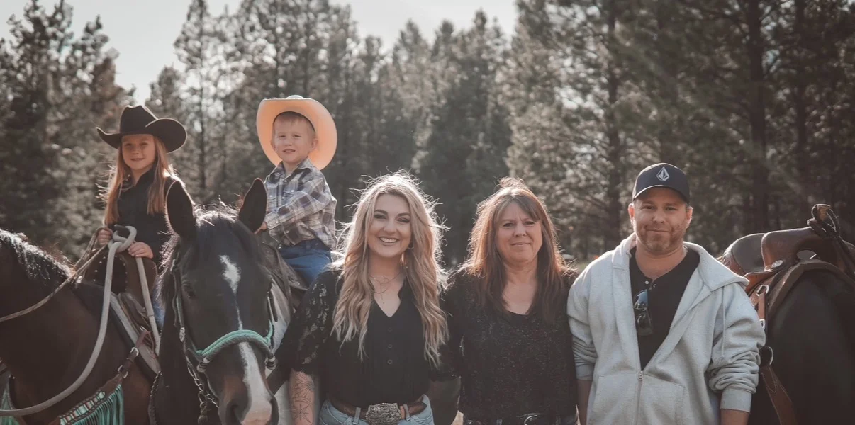 The Spur Valley Horses family standing with horses on the ranch